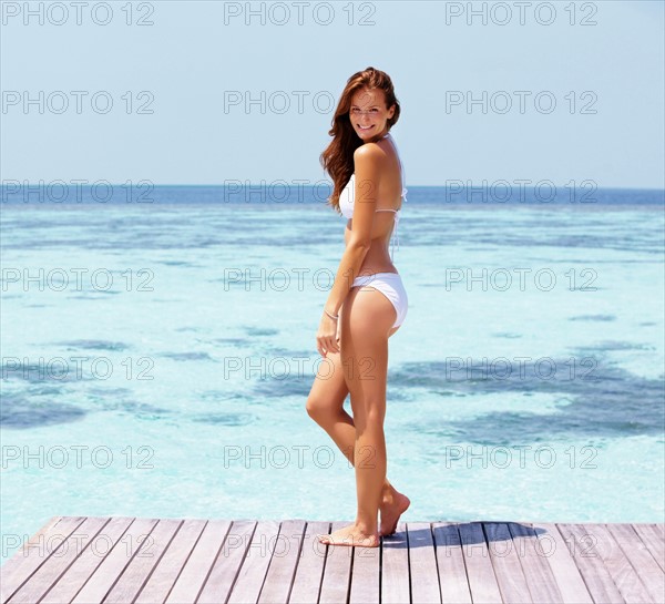 Young woman in bikini standing on jetty