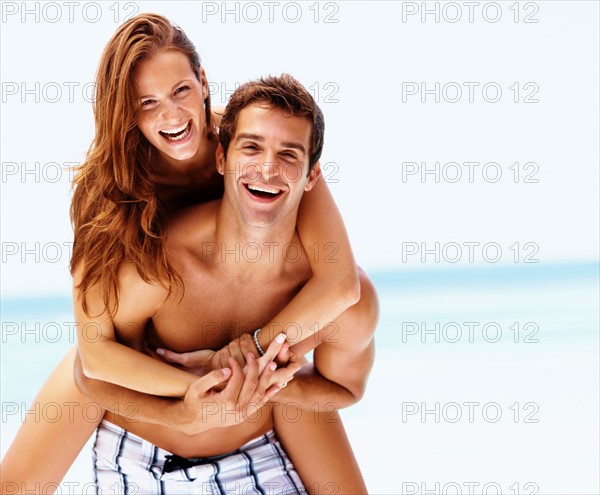 Young attractive couple enjoying summer holiday on beach