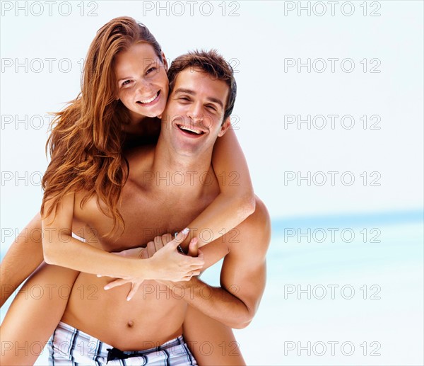 Young attractive couple enjoying summer holiday on beach