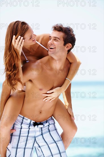 Young attractive couple enjoying summer holiday on beach