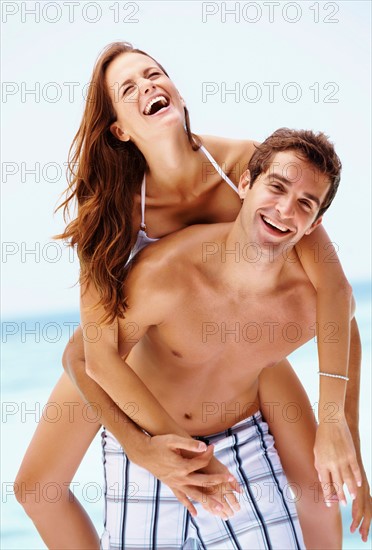 Young attractive couple enjoying summer holiday on beach