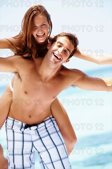 Young attractive couple enjoying summer holiday on beach