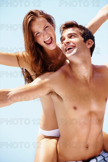 Young attractive couple enjoying summer holiday on beach