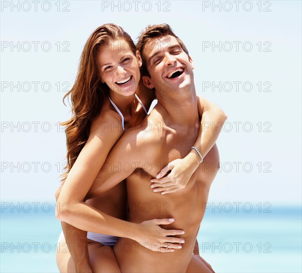 Young attractive couple enjoying summer holiday on beach