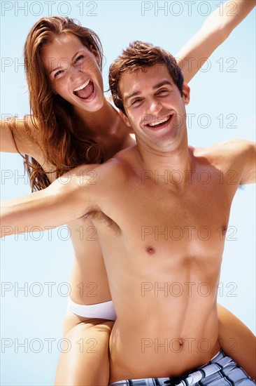 Young attractive couple enjoying summer holiday on beach