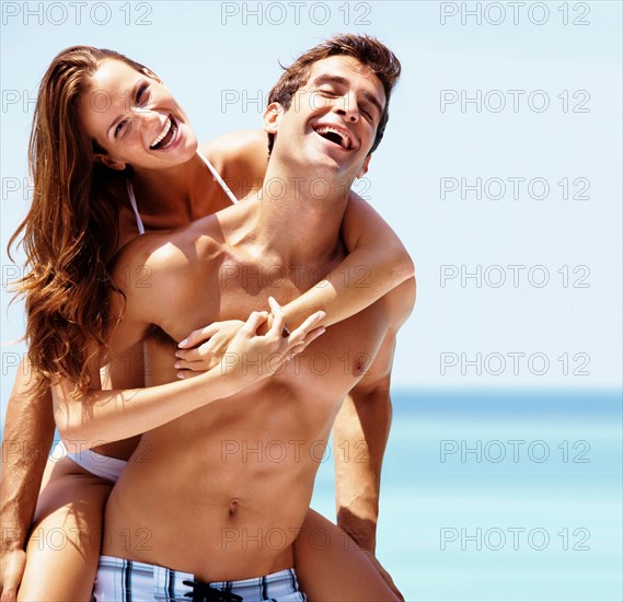 Young attractive couple enjoying summer holiday on beach