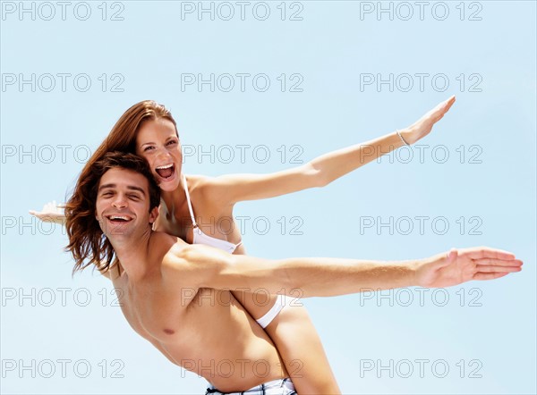 Young attractive couple enjoying summer holiday on beach