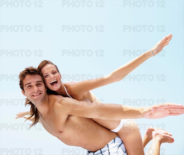 Young attractive couple enjoying summer holiday on beach