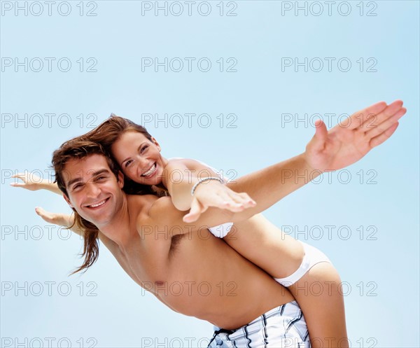Young attractive couple enjoying summer holiday on beach