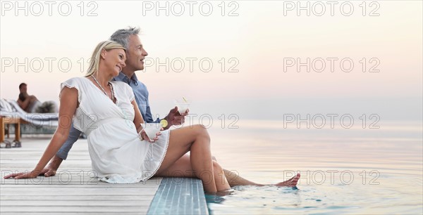 Mature couple sitting by seashore