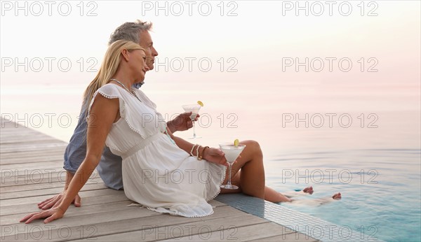 Mature couple sitting by seashore
