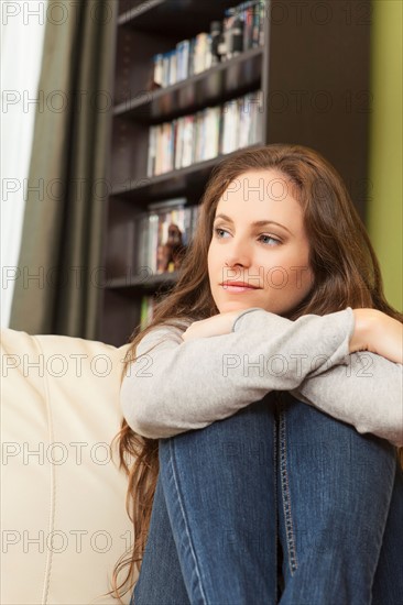 Smiling woman on sofa looking away