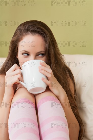 Woman sitting on sofa and holding mug