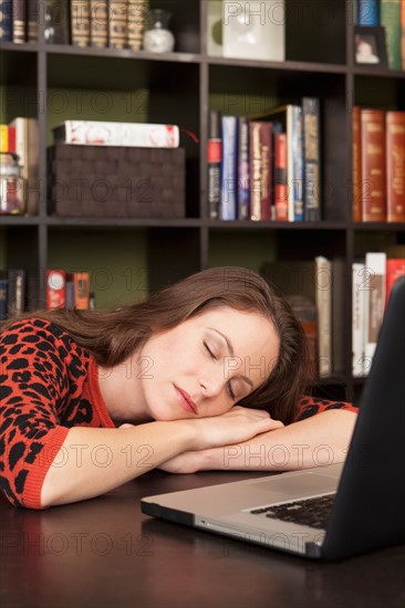 Woman sleeping next to laptop