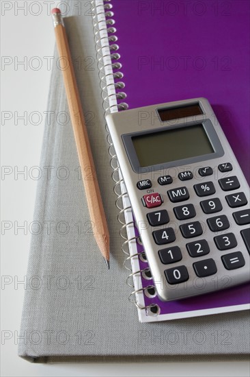 Calculator, textbook, pencil and notebook, studio shot