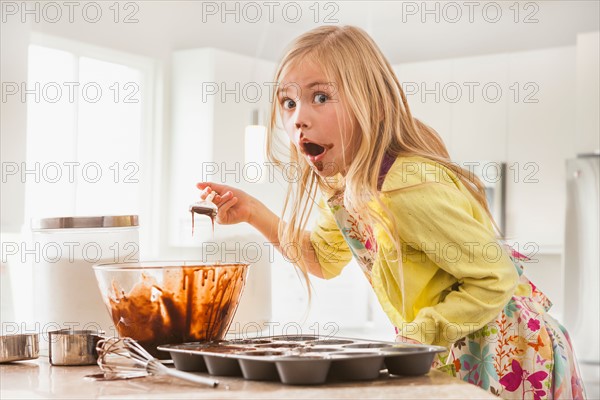 Girl (6-7) baking cupcakes