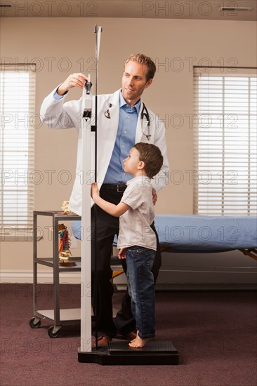 Boy (2-3) on scale in doctor's office