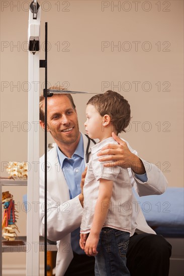 Boy (2-3) on scale in doctor's office