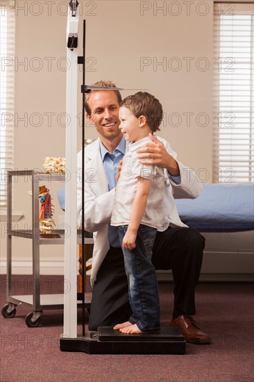 Boy (2-3) on scale in doctor's office