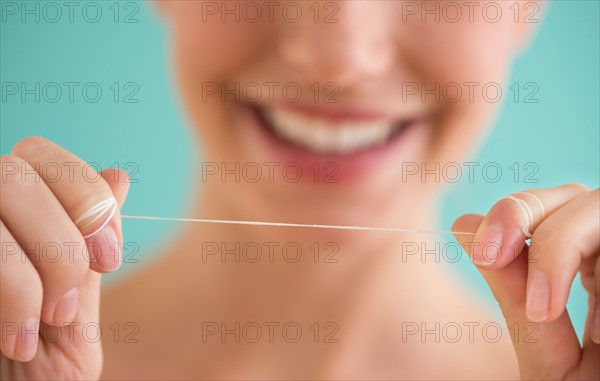 Close-up of woman holding dental floss.