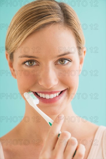 Portrait of woman brushing teeth.