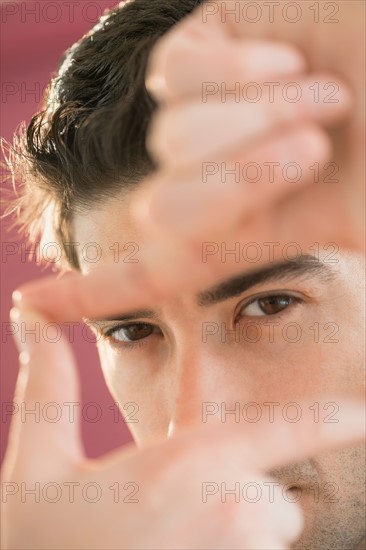 Portrait of man making finger frame.