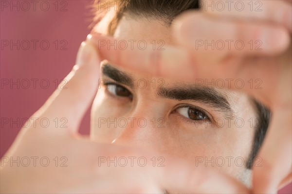 Portrait of man making finger frame.