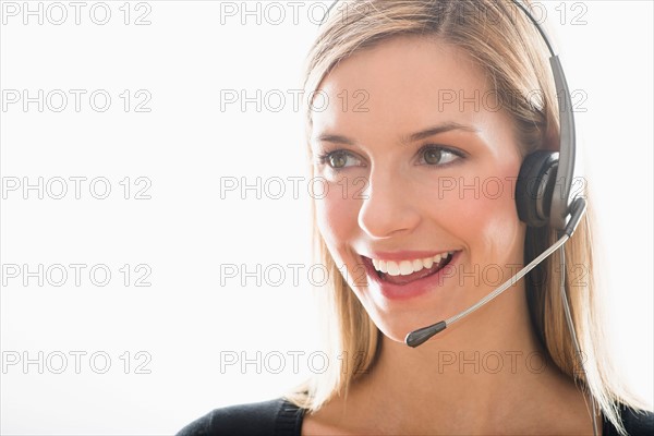 Studio portrait of young woman wearing headset.