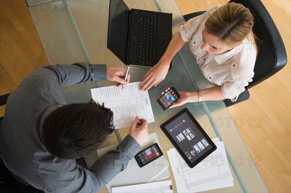 Business man and woman using mobile devices.