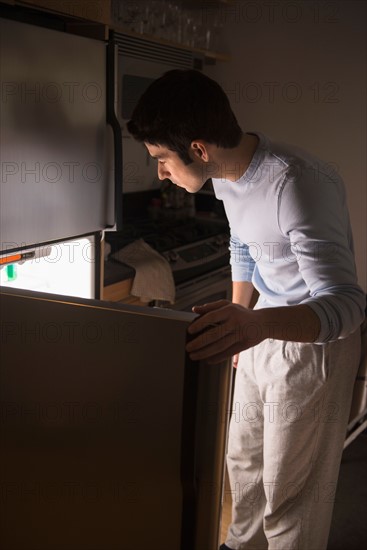 Man opening fridge at night.