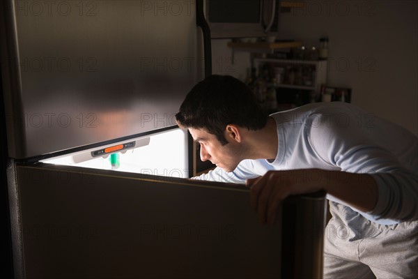 Man opening fridge at night.