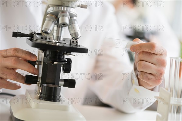 Close-up of scientist doing research on microscopes.