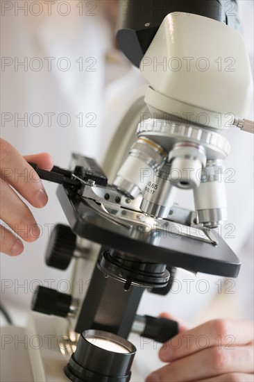 Close-up of scientist doing research on microscopes.