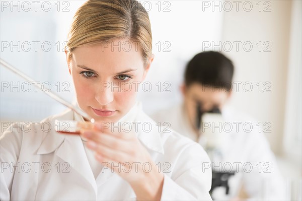 Scientist using pipette and petri dish.