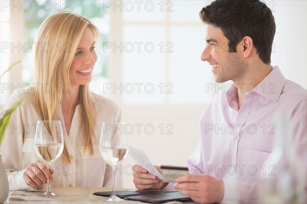 Couple in restaurant, man paying.