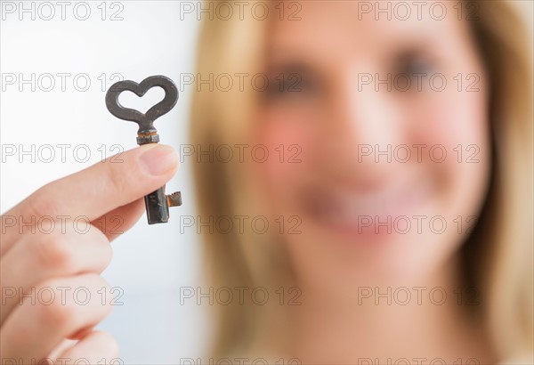 Woman holding heart-shaped key.