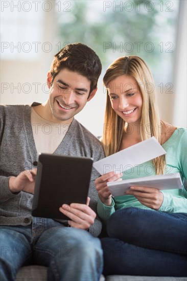 Couple using tablet pc to pay bills online.