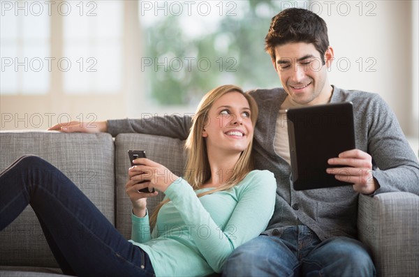 Couple using tablet pc and smartphone.