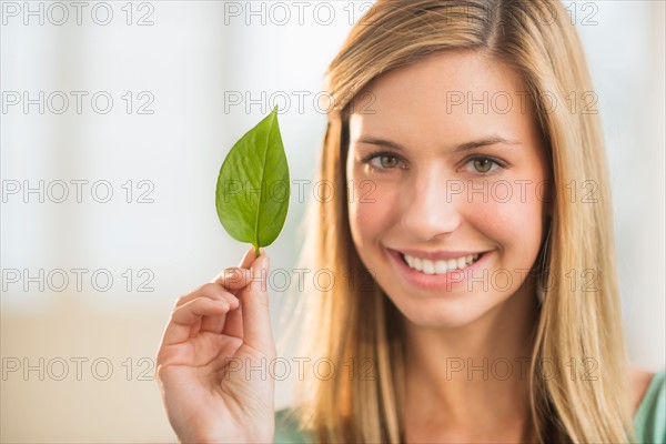 Portrait of woman holding leaf.