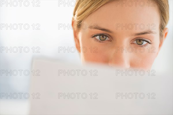 Close-up of young woman reading documents.