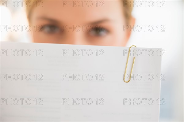 Close-up of young woman reading documents.