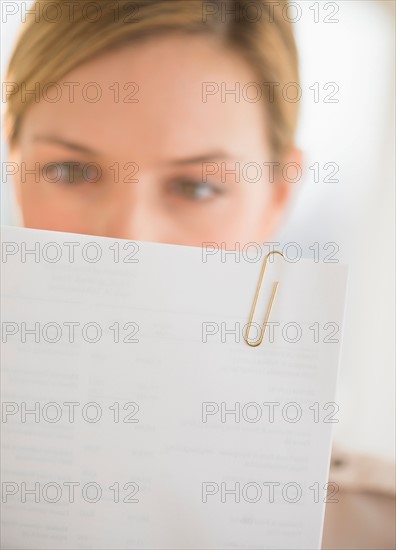 Close-up of young woman reading documents.