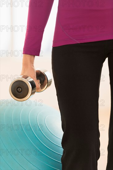 Woman holding dumbbell.