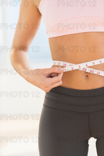 Woman measuring waist.