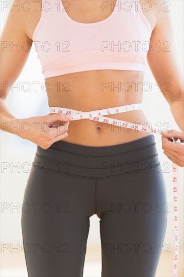 Woman measuring waist.