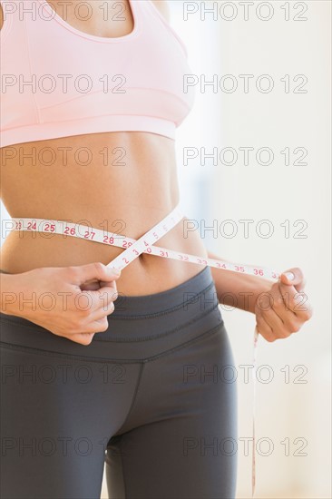 Woman measuring waist.