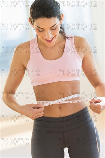 Woman measuring waist.