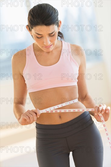 Woman measuring waist.