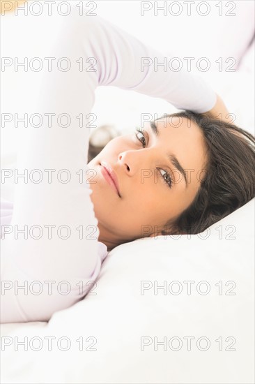 Portrait of woman lying in bed.