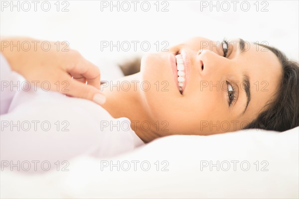 Portrait of woman lying in bed.